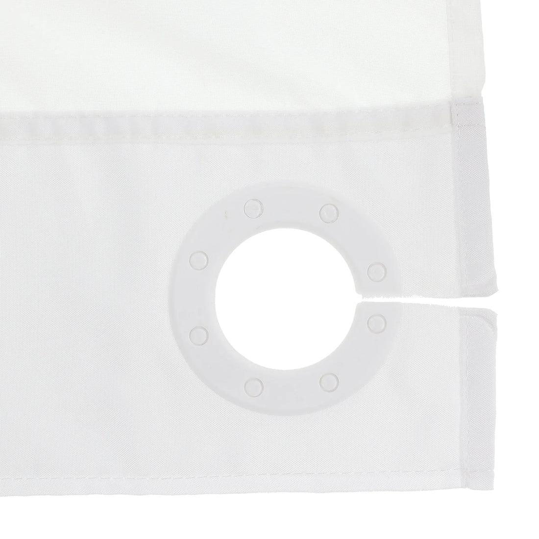 Close-up of a white curtain panel showing the fabric texture, stitched hem, and a circular grommet ring on the corner. - okotoks hc pharmacy