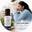 Bell Spring Calming essential oil blend bottle shown beside a woman in a light blue sweater in a softly blurred indoor setting. Text on the image reads 'CALM YOUR MIND. - okotoks hc pharmacy