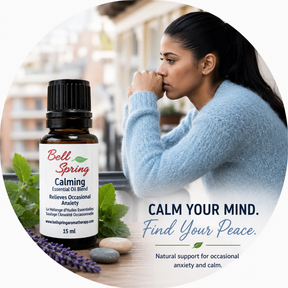 Bell Spring Calming essential oil blend bottle shown beside a woman in a light blue sweater in a softly blurred indoor setting. Text on the image reads 'CALM YOUR MIND. - okotoks hc pharmacy
