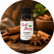 A 15 ml bottle of Bell Spring Cinnamon Essential Oil surrounded by cinnamon sticks, star anise, and a wooden bowl in a circular composition on a rustic wooden background. - okotoks hc pharmacy