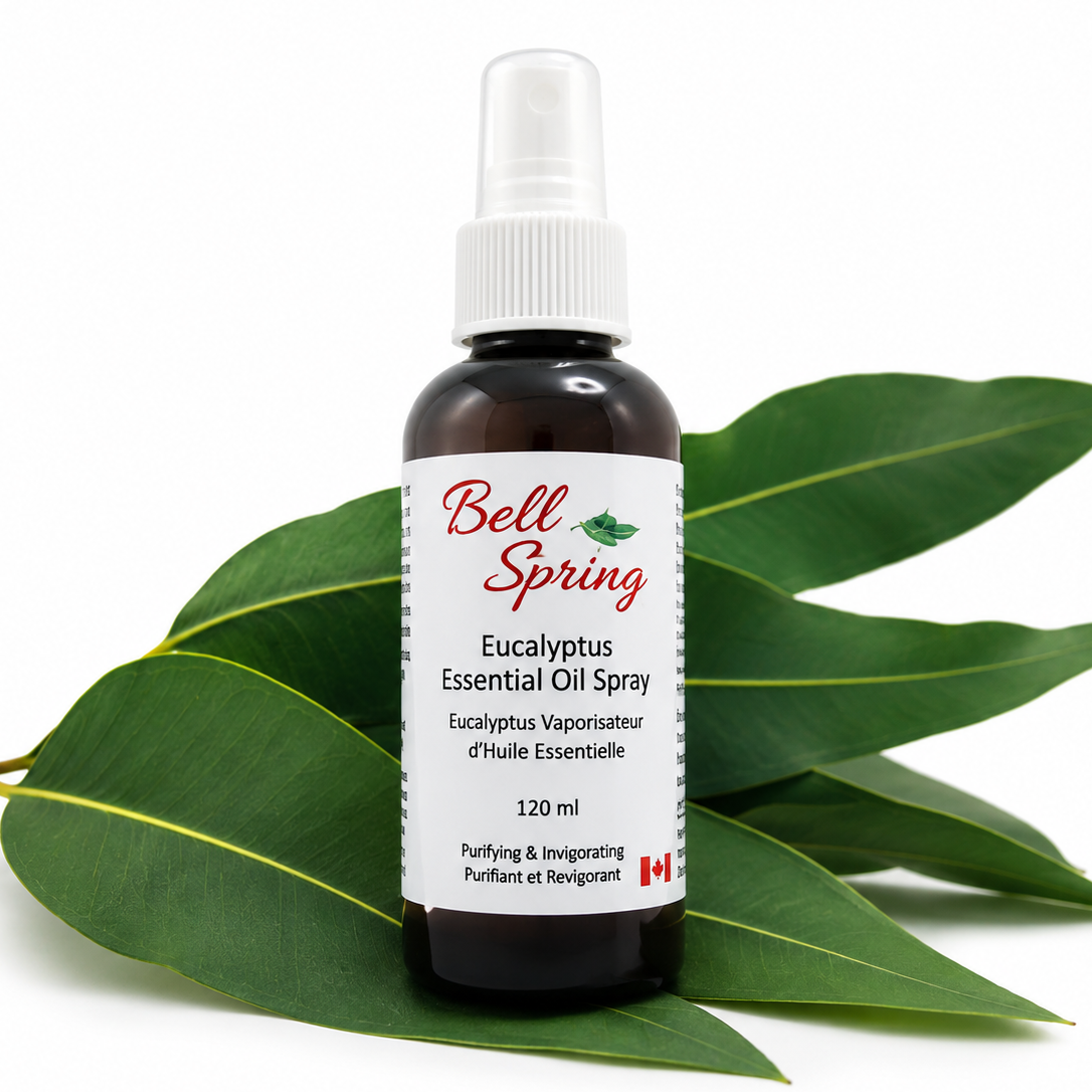 Bell Spring Eucalyptus Essential Oil Spray in a 120 ml amber glass bottle with a white spray cap, displayed on green eucalyptus leaves against a white background. - okotoks hc pharmacy