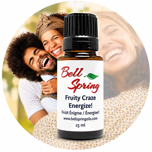 A 15 ml bottle of Bell Spring 'Fruity Craze Energize!' essential oil centered over a circular background photo of a smiling couple, with the product label clearly visible. - okotoks hc pharmacy