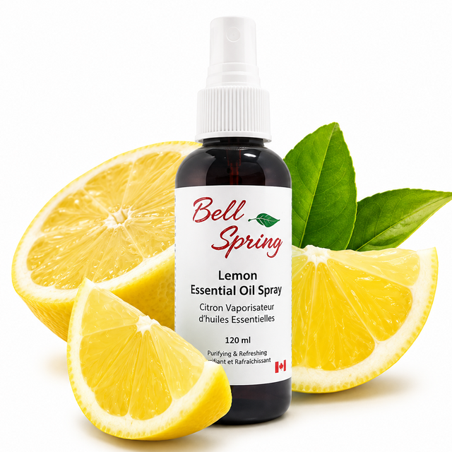 A bottle of Bell Spring Lemon Essential Oil Spray surrounded by fresh lemon slices and green leaves on a white background. - okotoks hc pharmacy