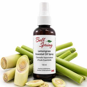 Bell Spring Lemongrass Essential Oil Spray bottle in amber glass with a white spray cap, surrounded by fresh green lemongrass stalks and sliced pieces on a white background. - okotoks hc pharmacy