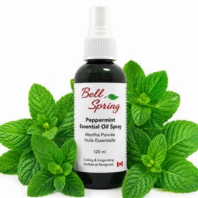 Bell Spring Peppermint Essential Oil Spray in a 120 ml dark glass bottle with a white spray cap, surrounded by fresh green peppermint leaves on a white background. - okotoks hc pharmacy