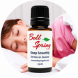 A 15 ml amber glass bottle of Bell Spring Sleep Smoothly essential oil with a black cap and white label, shown in front of a circular background depicting a sleeping child. - okotoks hc pharmacy
