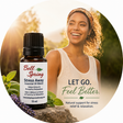A circular promotional graphic featuring a small bottle of Bell Spring Stress Away essential oil blend alongside a smiling woman in a white tank top in an outdoor setting. Text on the image reads 'LET GO. - okotoks hc pharmacy
