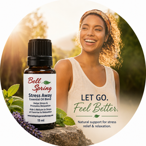 A circular promotional graphic featuring a small bottle of Bell Spring Stress Away essential oil blend alongside a smiling woman in a white tank top in an outdoor setting. Text on the image reads 'LET GO. - okotoks hc pharmacy