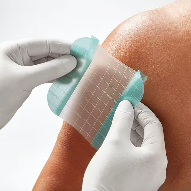 Person applying a grid-patterned adhesive patch to a person's arm with gloves on. - okotoks hc pharmacy