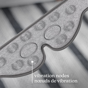Close-up of a gray textured wearable device with oval and circular vibration nodes, overlaid with the text 'vibration nodes / nœuds de vibration' on a blurred striped background. - okotoks hc pharmacy