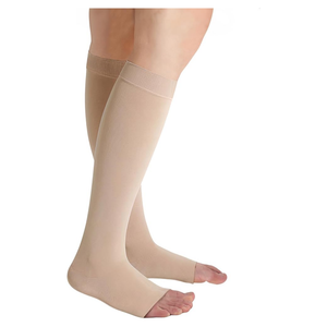 Beige over-the-calf compression socks worn on a model's legs, shown against a plain white background. - okotoks hc pharmacy