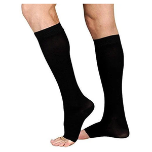 A pair of black knee-high compression socks worn on a person's legs, shown against a plain white background. - okotoks hc pharmacy