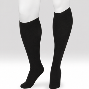 A pair of black knee-high compression socks or calf sleeves shown on a white mannequin lower leg and foot form against a light gray studio background. - okotoks hc pharmacy