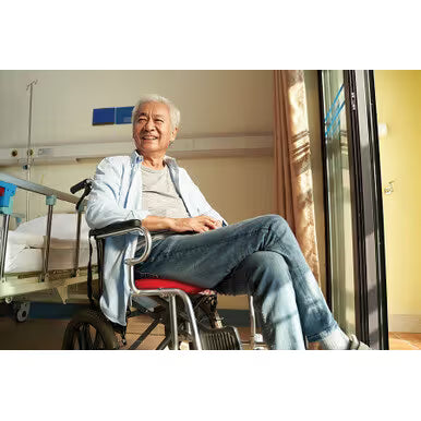 Man sitting in a wheelchair in a hospital room with a window in the background - okotoks hc pharmacy
