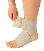 A beige ankle support brace being adjusted on a person's ankle by a hand, shown against a plain white background. - okotoks hc pharmacy