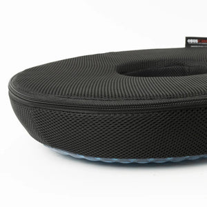 A black textured zippered hard case with a circular opening, shown on a clean white background. A small black brand tag is visible on the upper right edge. - okotoks hc pharmacy