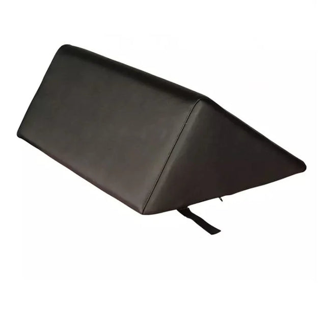 A black wedge-shaped support cushion or pillow with a small black strap hanging from the bottom corner, shown on a plain white background. - okotoks hc pharmacy