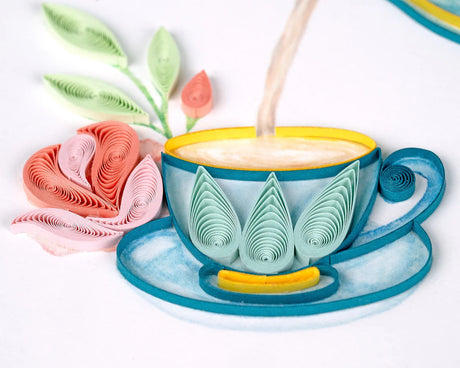 Decorative teacup with floral design being filled with milk, surrounded by paper flowers on a white background. - okotoks hc pharmacy