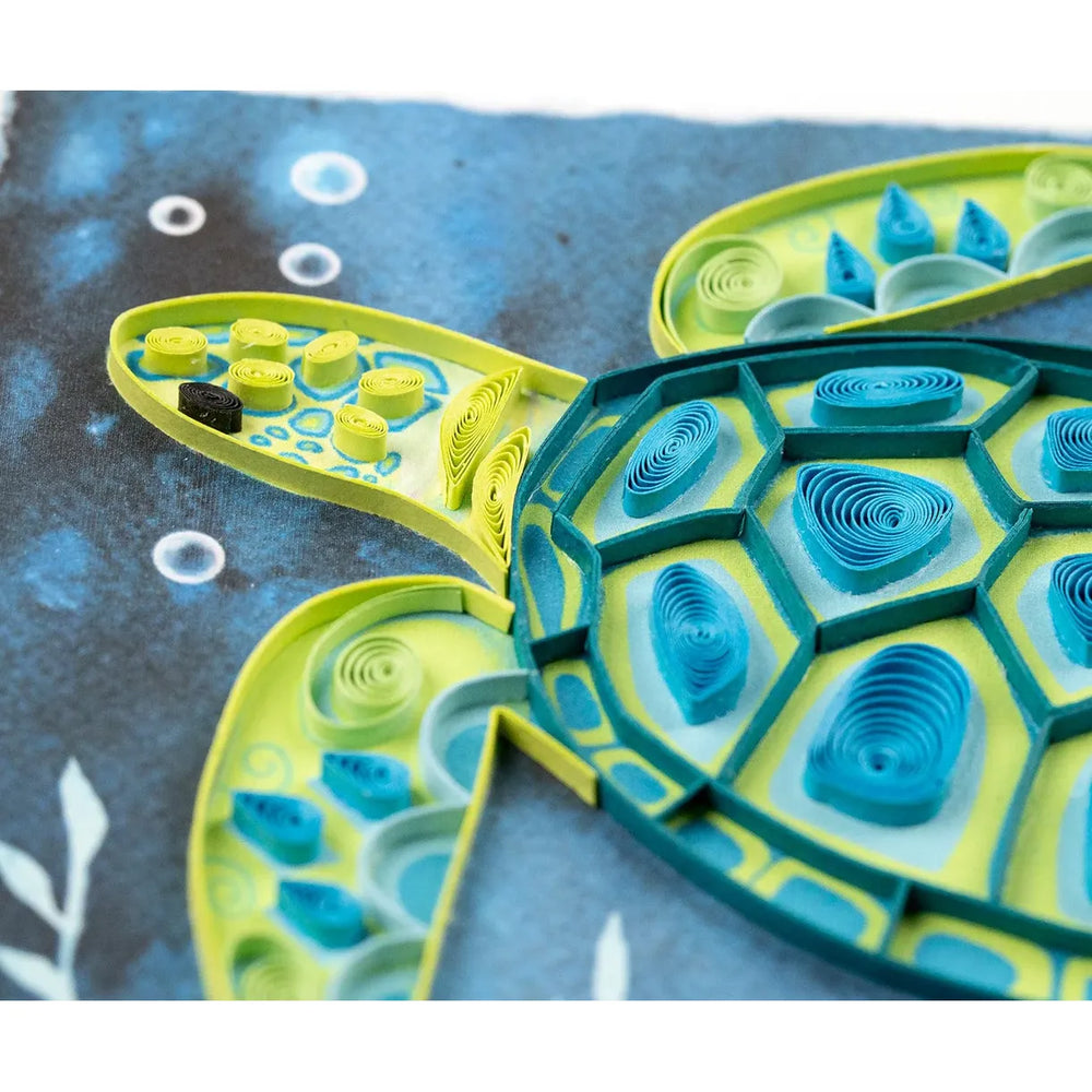 Quilled turtle art with green and blue patterns on a textured surface - okotoks hc pharmacy