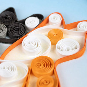 Set of colorful paper rolls in a decorative holder on a light blue background - okotoks hc pharmacy