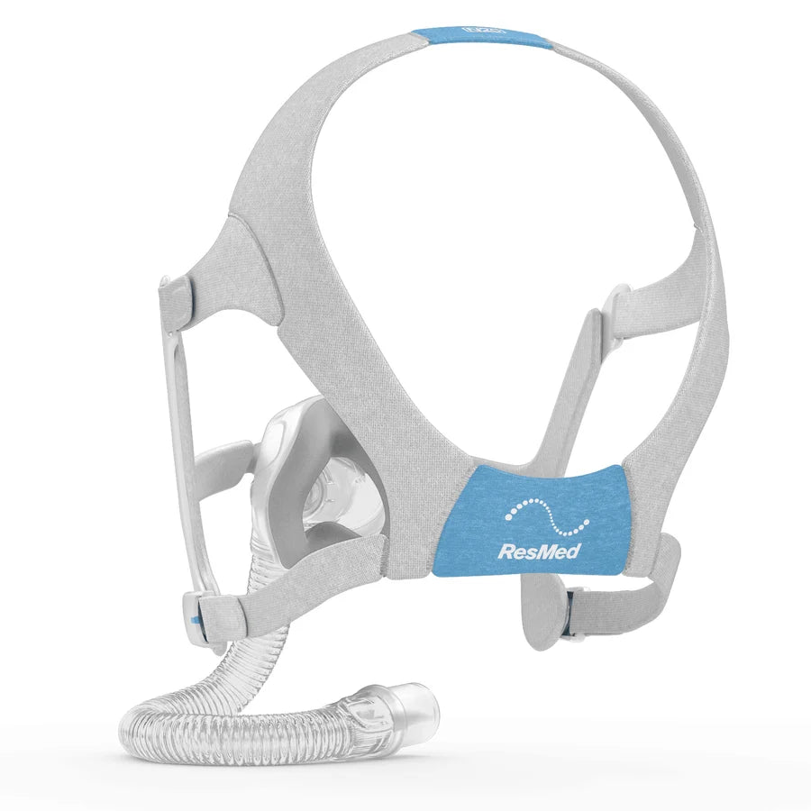 ResMed CPAP mask with a light gray fabric headband, blue accent pads, and a clear flexible breathing tube on a white background. - okotoks hc pharmacy