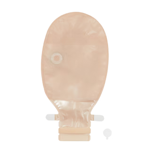 A beige skin-tone disposable abdominal ostomy bag with a central drain hole and a short connector tube, shown on a plain white background with a small matching accessory piece at the bottom right. - okotoks hc pharmacy