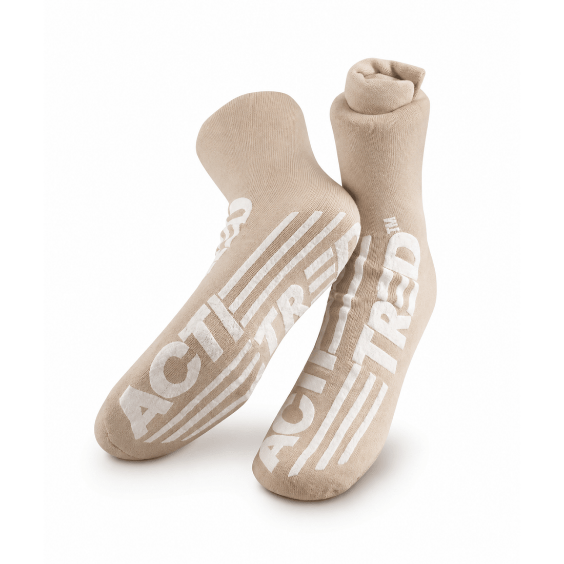 A pair of beige crew socks with bold white 'ACT! TREAD' text and stripe graphics on the soles, displayed against a clean white background. - okotoks hc pharmacy