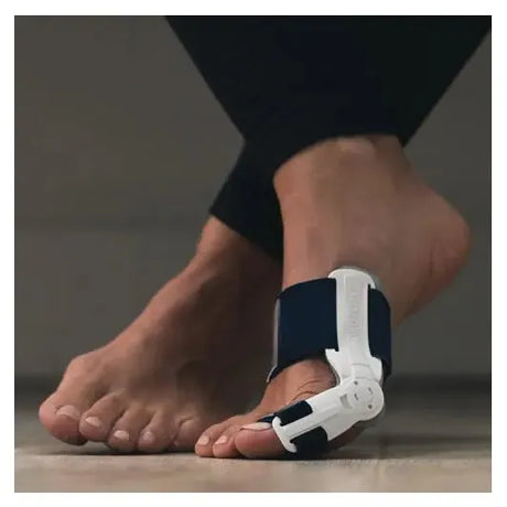 Person wearing a white and black foot orthotic device on a neutral background - okotoks hc pharmacy