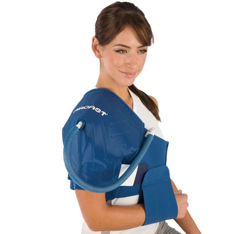 Woman wearing a blue shoulder brace with a visible brand logo on a white background - okotoks hc pharmacy