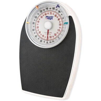 Mechanical weight scale with a black base and white top on a white background - okotoks hc pharmacy