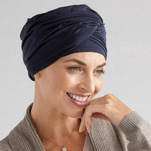 Woman wearing a night blue headscarf on a gray background - Okotoks HC Pharmacy