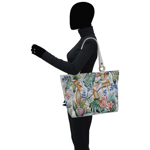 Person holding a floral-patterned handbag on a white background - okotoks hc pharmacy