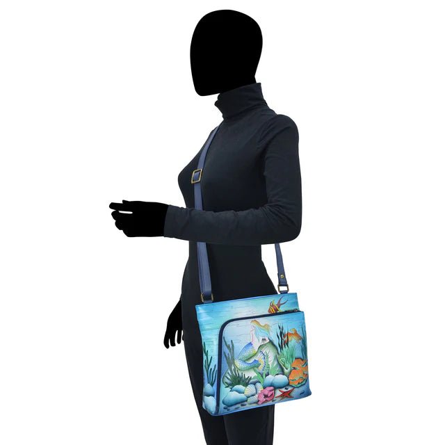 Person wearing a dark outfit with a colorful bag featuring an underwater scene. - okotoks hc pharmacy