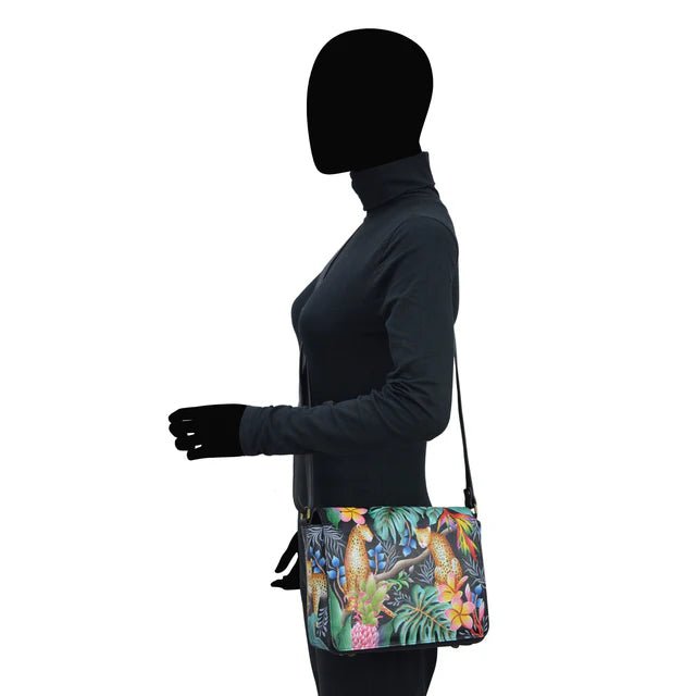 Person wearing a black jacket and gloves with a colorful bag featuring parrot design - okotoks hc pharmacy