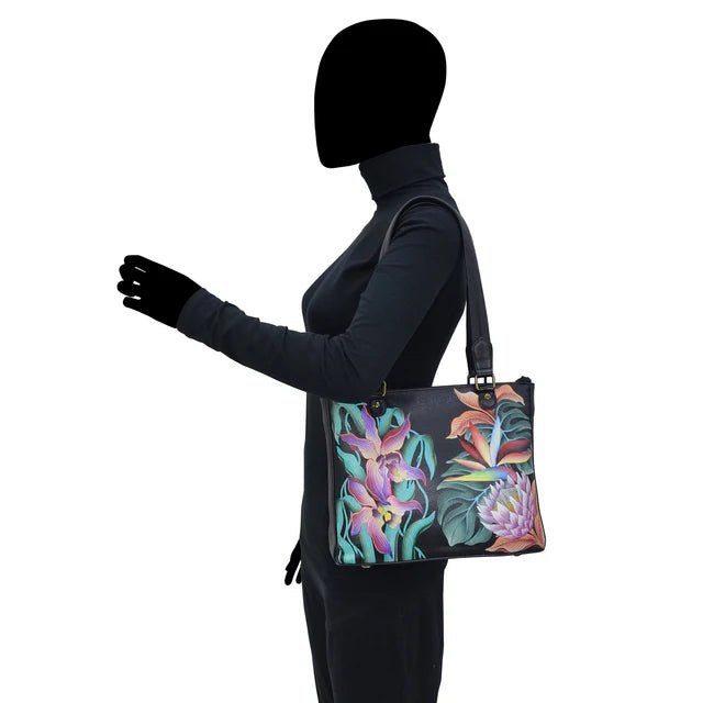 Person wearing a black outfit with a floral-patterned handbag on a white background - okotoks hc pharmacy