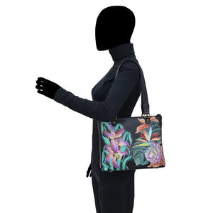 Person wearing a black outfit with a floral-patterned handbag on a white background - okotoks hc pharmacy