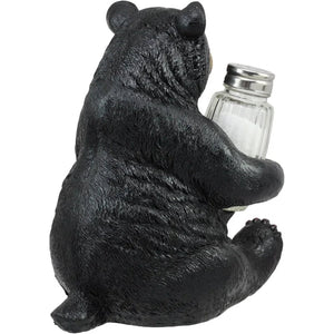 Black bear figurine holding a salt shaker on a white background - okotoks hc pharmacy