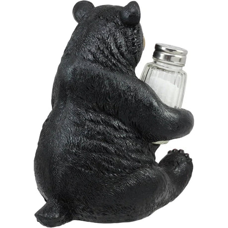 Black bear figurine holding a salt shaker on a white background - okotoks hc pharmacy