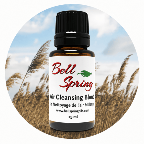 A 15 ml bottle of Bell Spring Air Cleansing Blend essential oil on a circular background depicting a field of reeds under a blue sky. - okotoks hc pharmacy