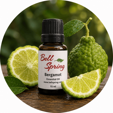 Bell Spring Bergamot essential oil bottle with a black cap, surrounded by fresh bergamot fruits and lime slices on a wooden surface with a blurred green background. - okotoks hc pharmacy