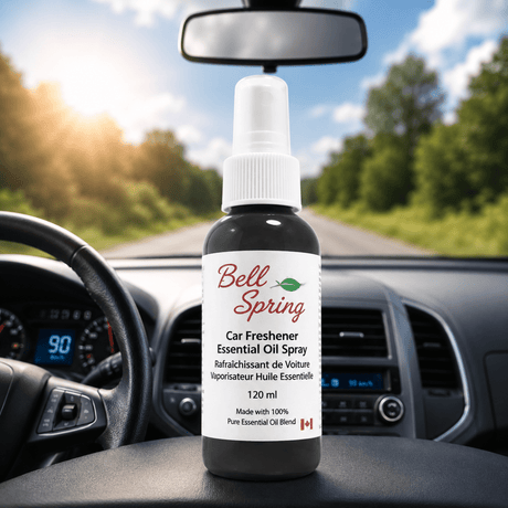 Bell Spring Car Freshener Essential Oil Spray bottle on a car dashboard with a blurred road and trees in the background. - okotoks hc pharmacy