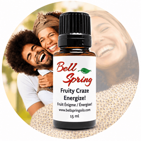 A 15 ml bottle of Bell Spring 'Fruity Craze Energize!' essential oil centered over a circular background photo of a smiling couple, with the product label clearly visible. - okotoks hc pharmacy