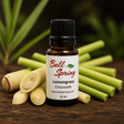 A 15 ml amber glass bottle of Bell Spring Lemongrass Citronnelle essential oil, styled with fresh lemongrass stalks on a rustic wooden surface with a dark, blurred natural background. - okotoks hc pharmacy