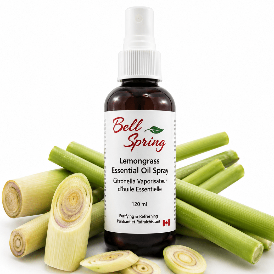 Bell Spring Lemongrass Essential Oil Spray bottle in amber glass with a white spray cap, surrounded by fresh green lemongrass stalks and sliced pieces on a white background. - okotoks hc pharmacy