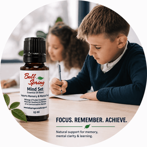 A 10 mL bottle of Bell Spring Mind Set essential oil blend is shown in the foreground, with a boy studying at a desk in a softly blurred classroom background. The image is framed in a circular graphic with the text 'FOCUS. - okotoks hc pharmacy