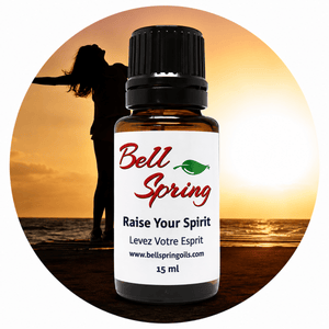A 15 ml amber glass essential oil bottle with a black cap and a white label reading 'Bell Spring' and 'Raise Your Spirit', centered over a circular beach sunset background with a silhouetted person. - okotoks hc pharmacy