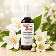 Bell Spring Sweet Jasmine Essential Oil Spray in a dark amber bottle with a white spray top and white label, surrounded by white jasmine flowers and green leaves on a light wooden surface with a soft blurred background. - okotoks hc pharmacy