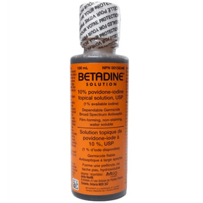 Bottle of Betadine solution with orange label on a white background - Okotoks HC Pharmacy