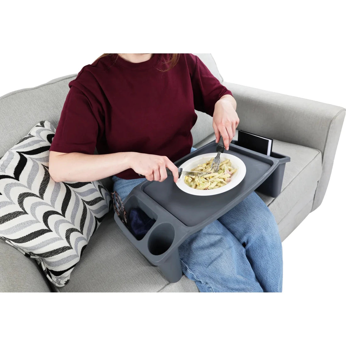 Person sitting on a couch using a portable dining tray to eat. - okotoks hc pharmacy