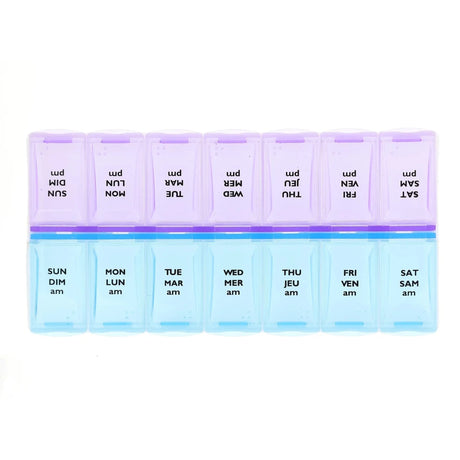 A 7-day weekly pill organizer with translucent plastic compartments. The top row is light purple with black text showing reversed days of the week (SUN, MON, etc. - okotoks hc pharmacy